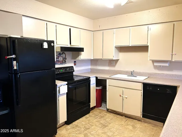 a kitchen with a sink a refrigerator and cabinets