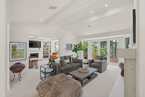 a living room with furniture a fireplace and a large window