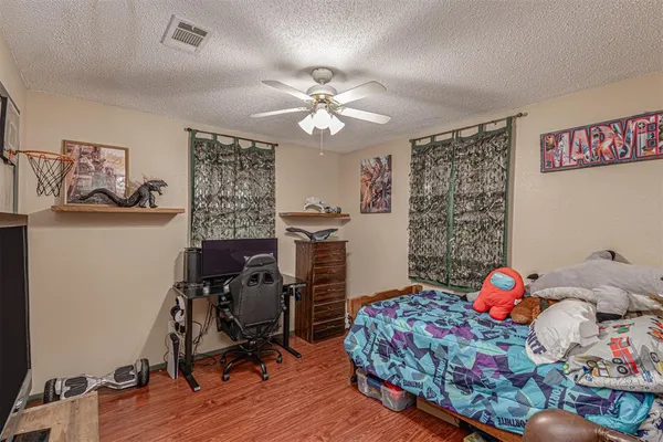 a bedroom with a bed and wooden floor
