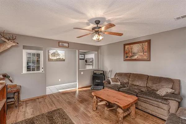 a living room with furniture a desk and chair with wooden floor