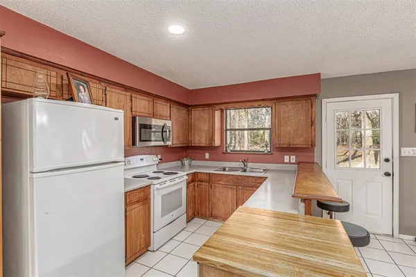 a kitchen with a refrigerator a stove a sink a washer dryer and cabinets