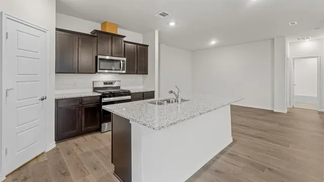 a kitchen with stainless steel appliances granite countertop a sink stove and refrigerator