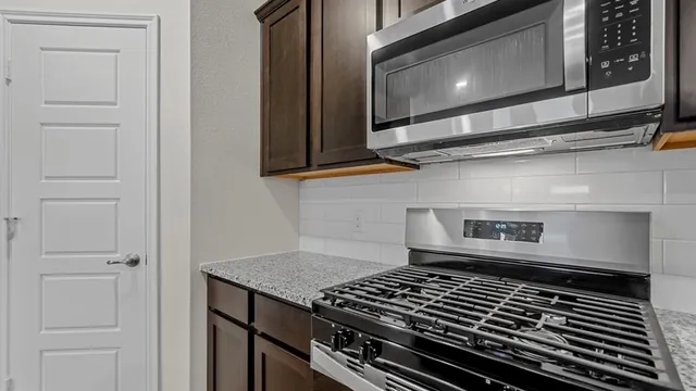 a stove top oven sitting inside of a kitchen