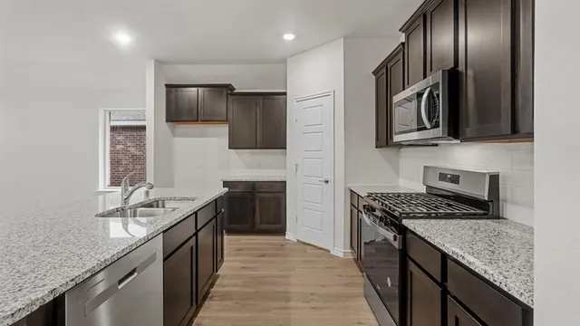 a view of kitchen with sink microwave and refrigerator
