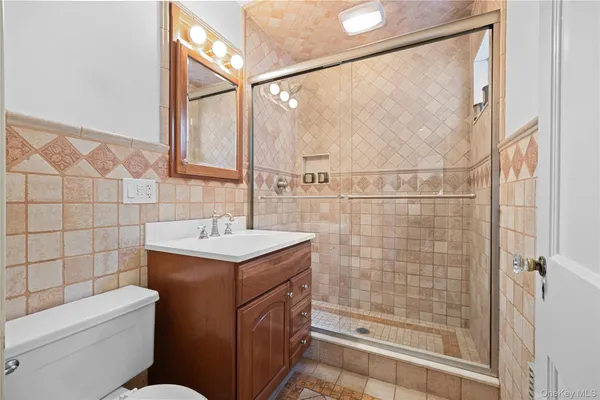 a bathroom with a sink toilet vanity and shower
