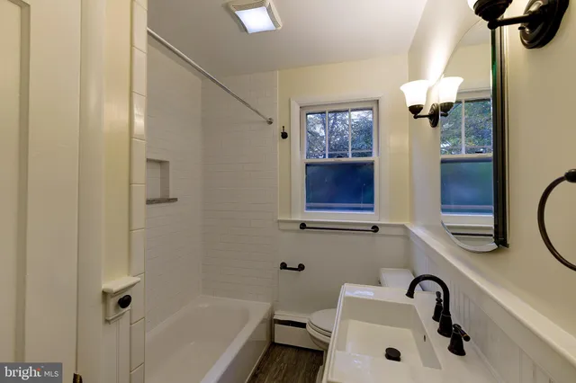 a bathroom with a sink and mirror with bathtub
