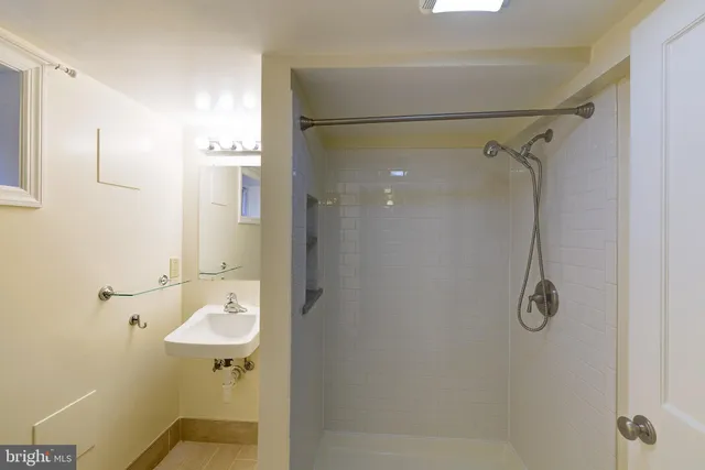 a bathroom with a shower sink vanity and mirror