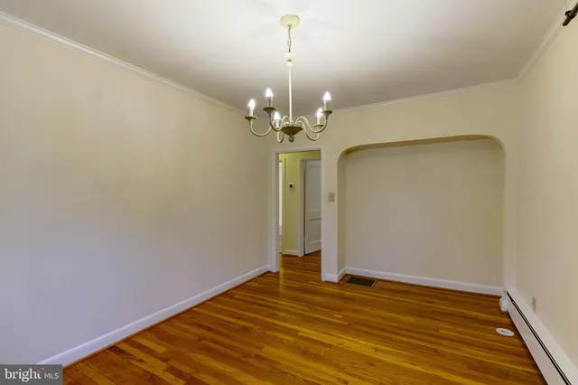 a view of a room with wooden floor and chandelier