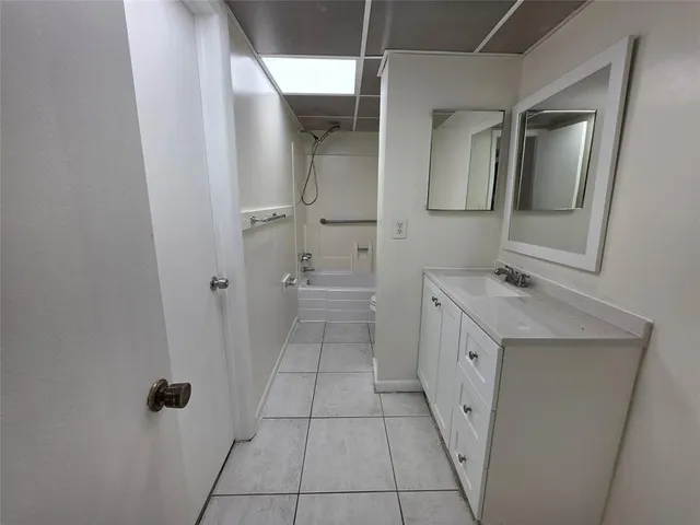 a bathroom with a granite countertop sink mirror and toilet