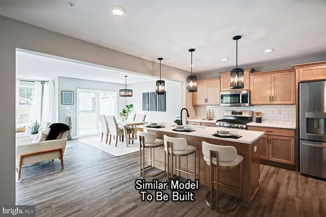 a kitchen with stainless steel appliances a dining table chairs stove and refrigerator