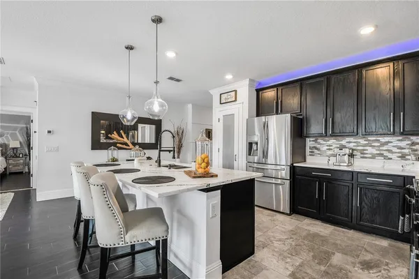 a kitchen with stainless steel appliances granite countertop a sink a stove a refrigerator and island