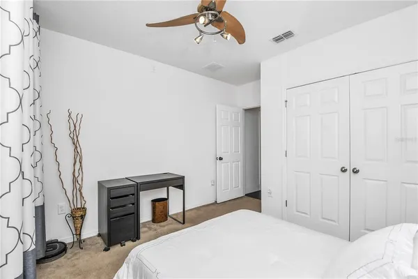 a bedroom with a large bed and a chandelier