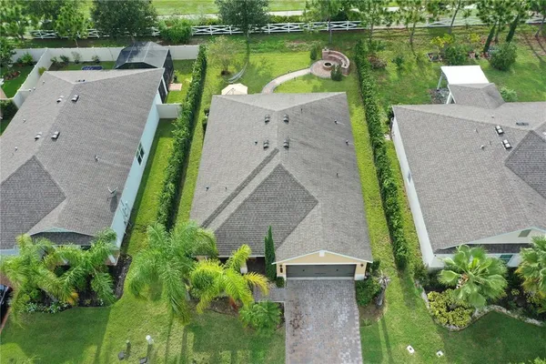 an aerial view of a house with a garden and lake view