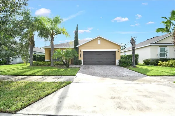 a front view of a house with yard and green space