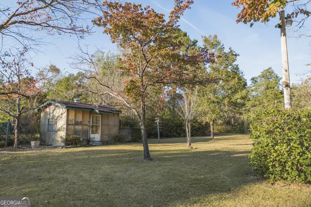 a view of a white house with a big yard and large trees