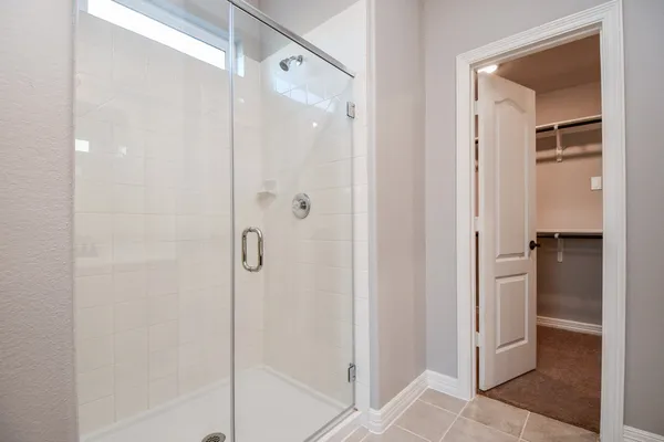 a bathroom with a shower and a glass door
