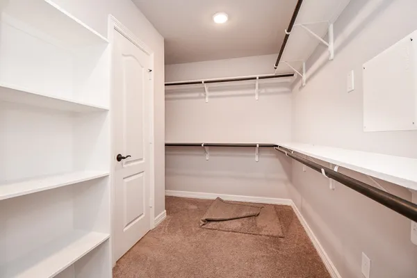 a view of walk in closet with empty racks