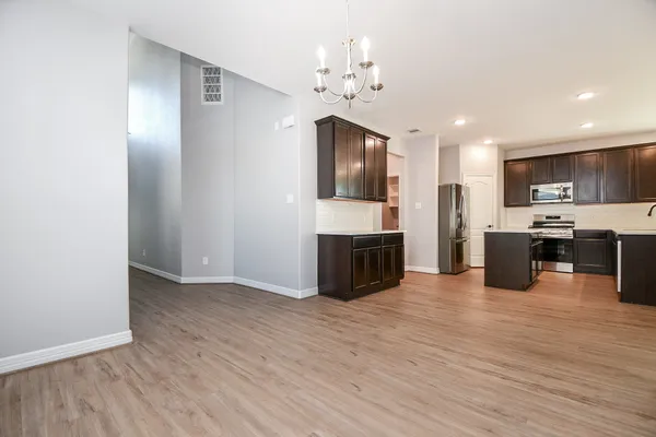 a open kitchen with cabinets stainless steel appliances and wooden floor