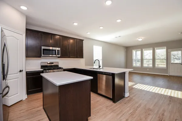 a kitchen with stainless steel appliances granite countertop a sink stove and refrigerator