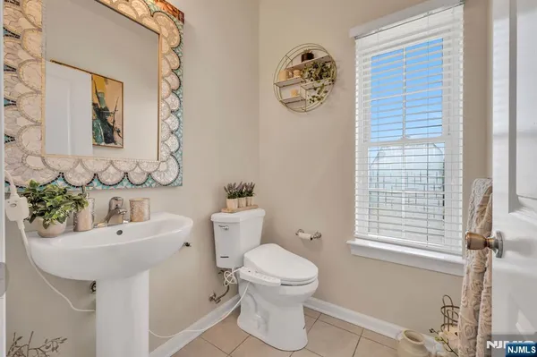 a bathroom with a sink mirror toilet and next to a window