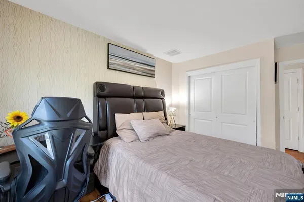 a bedroom with a bed a chair and potted plant on the table