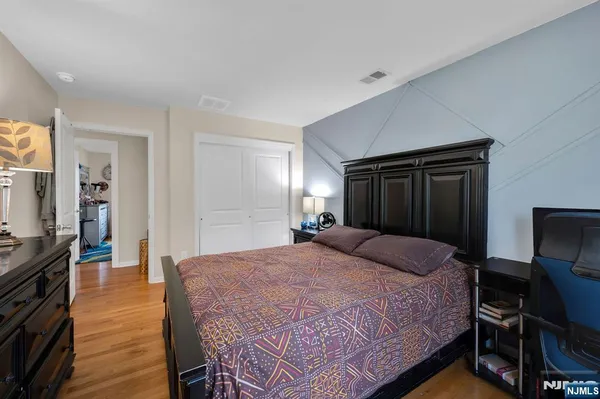 a bedroom with a bed and a mirror on dresser