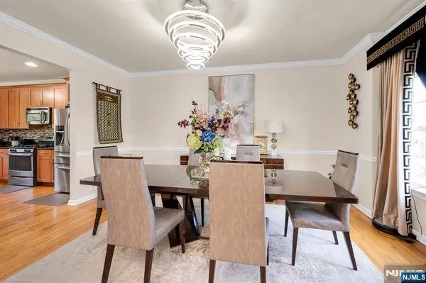 a dining room with furniture a chandelier and wooden floor