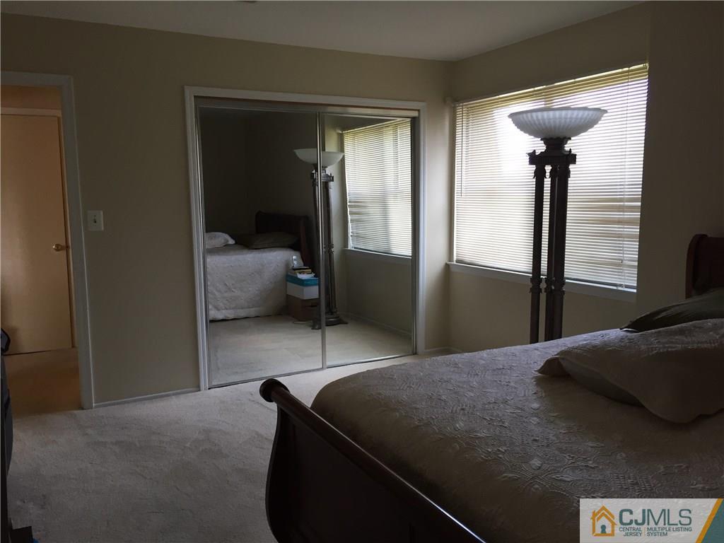 1623 Raspberry Court, Unit 1623 Edison, NJ 08817 - Photo 13 of 18 a bedroom with a bed and a lamp
