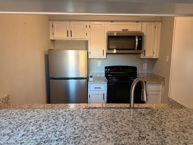 a kitchen with a refrigerator and a stove