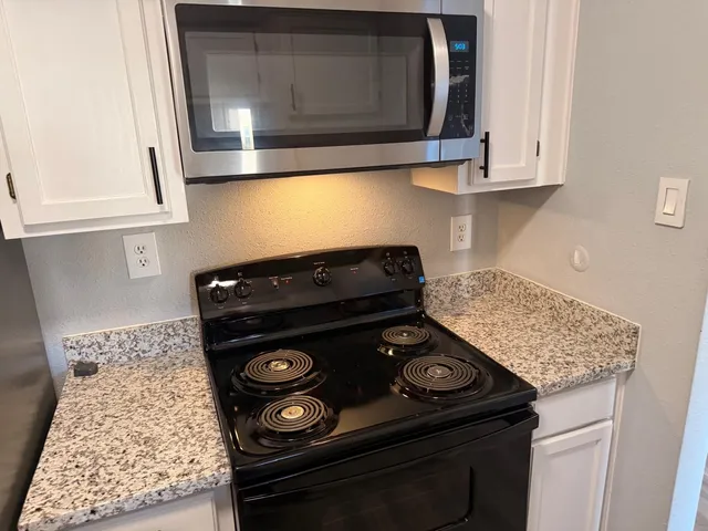 a stove top oven sitting inside of a kitchen
