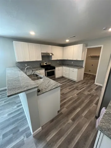 a kitchen with stainless steel appliances granite countertop a sink stove and cabinets