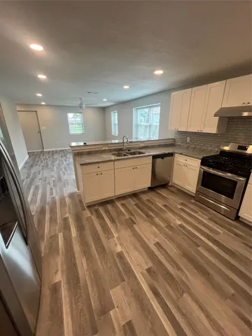 a large kitchen with kitchen island a sink stainless steel appliances and cabinets