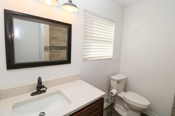 a bathroom with a sink a toilet and mirror