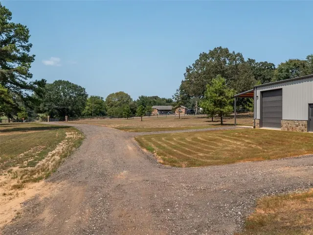 a big yard with trees in front of it