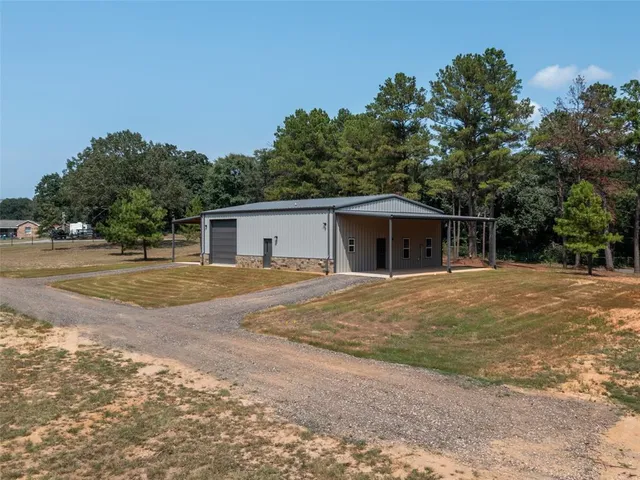 a view of a house with backyard and trees