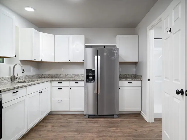 a view of empty room with wooden floor and window