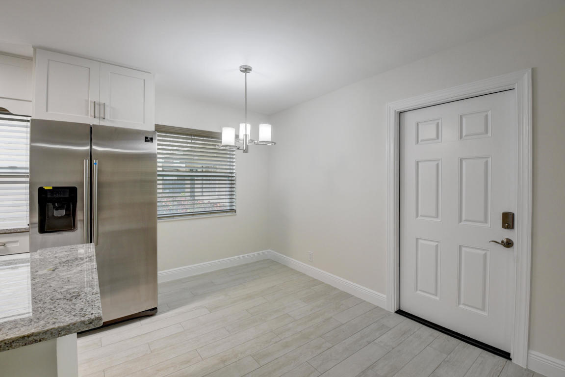76 Flanders B Delray Beach, FL 33484 - Photo 4 of 35 wooden floor in an empty room with a fireplace