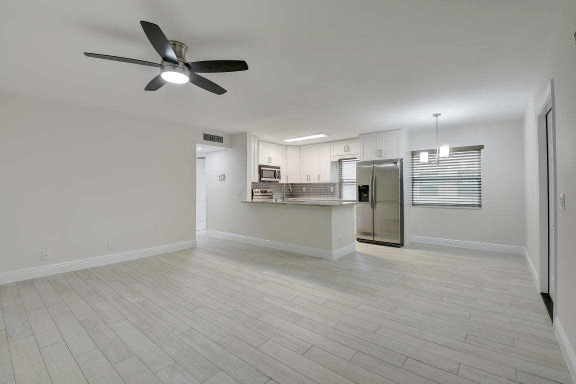 76 Flanders B Delray Beach, FL 33484 - Photo 9 of 35 a view of a kitchen with a sink refrigerator cabinets and wooden floor