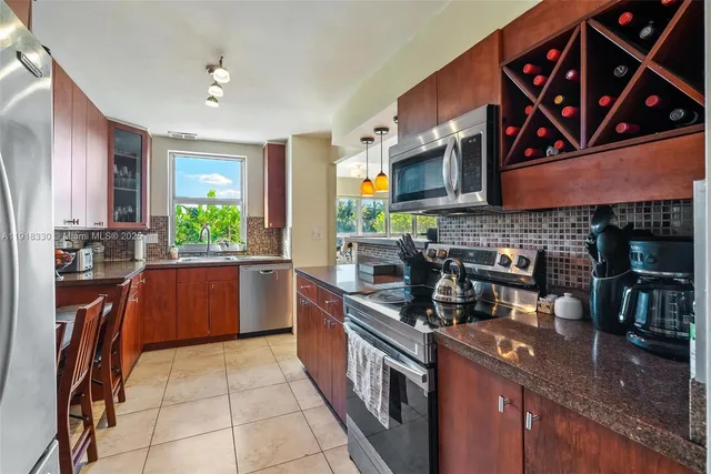 a kitchen with stainless steel appliances granite countertop a stove a sink and a microwave