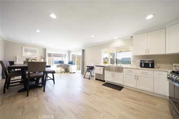 a large white kitchen with lots of white cabinets appliances and furniture