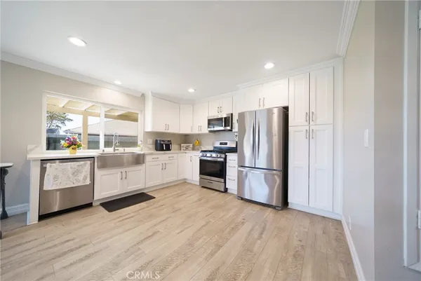 a kitchen with white cabinets and stainless steel appliances