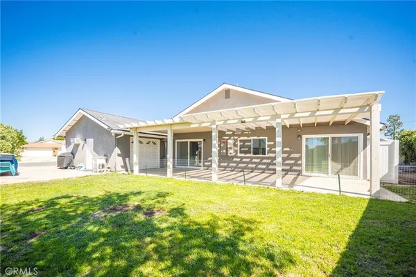 a view of a house with a yard and sitting area