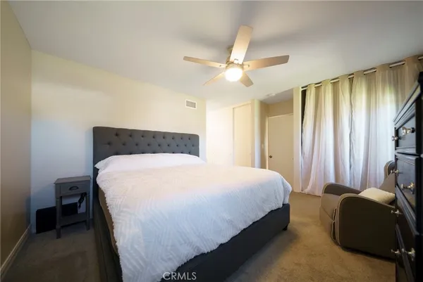 a bedroom with a bed lamp and a large window