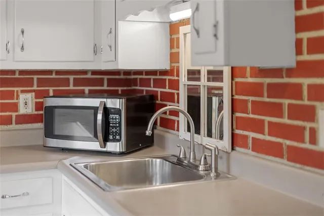 a close view of a sink a faucet a washer and dryer