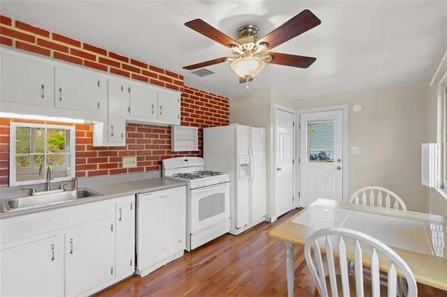 a kitchen with stainless steel appliances granite countertop a sink a stove and a refrigerator