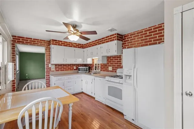 a kitchen with stainless steel appliances granite countertop a sink and dishwasher a refrigerator with wooden floor