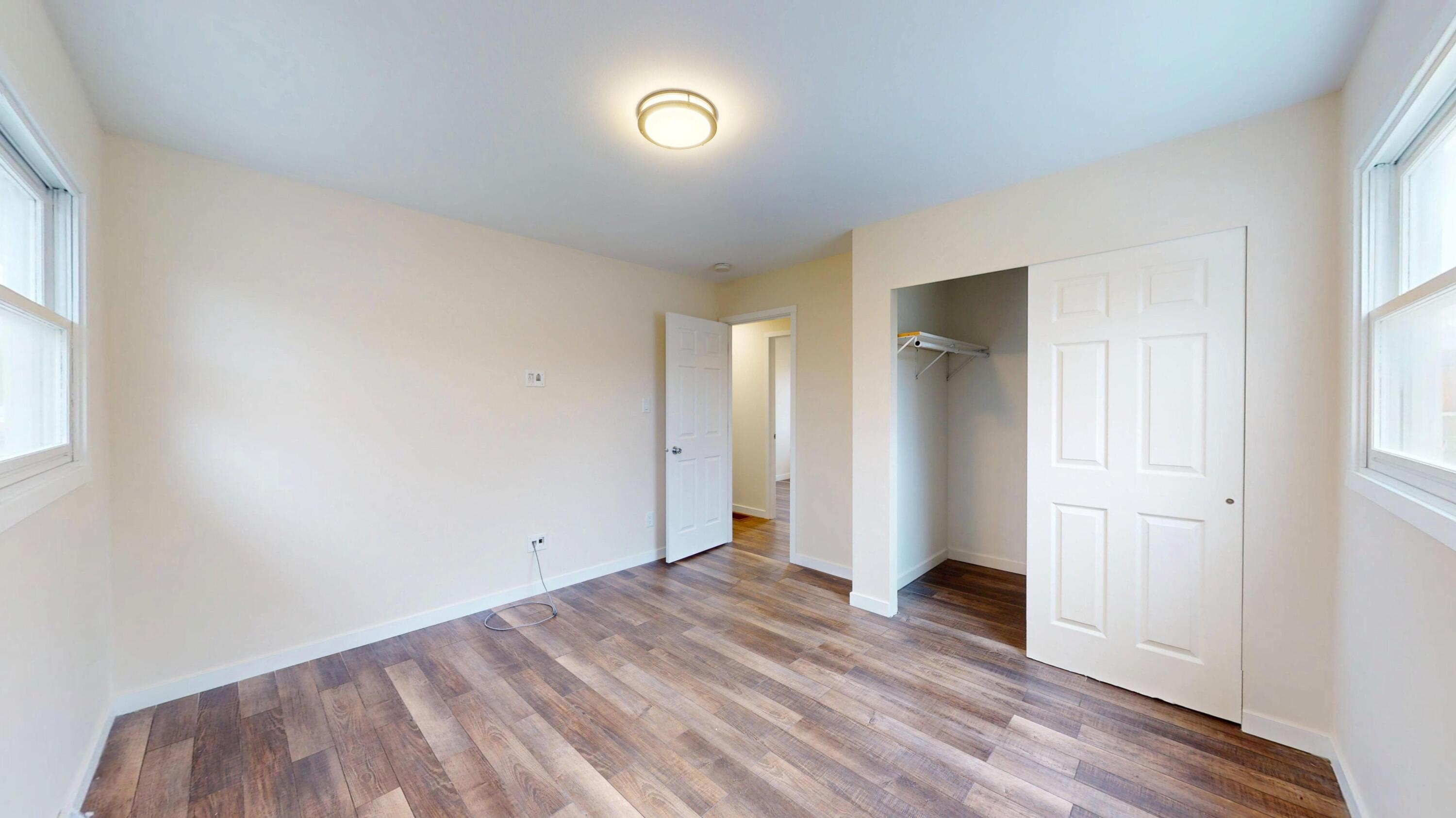 317 Redpath Avenue Michigan City, IN 46360 - Photo 10 of 40 an empty room with wooden floor and windows