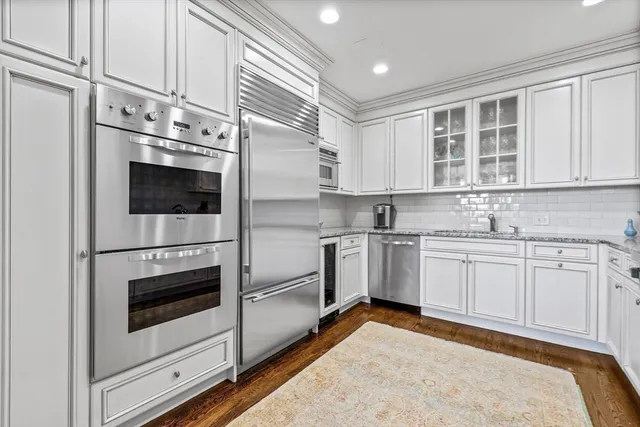 a kitchen with stainless steel appliances granite countertop a stove a sink and a microwave