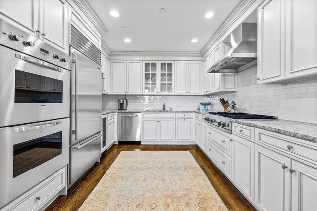 a kitchen with granite countertop white cabinets stainless steel appliances and sink