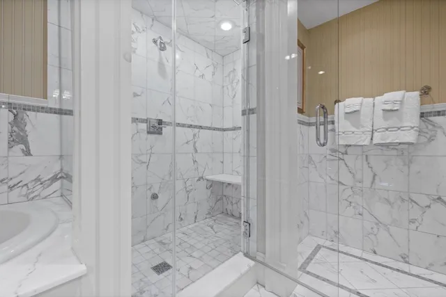 a bedroom with a bed a mirror on desk and chair